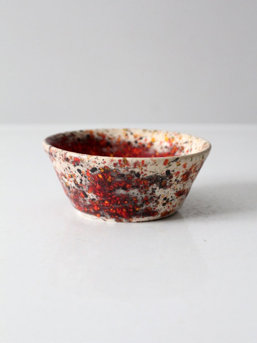 Organic modern ceramic studio bowl with red speckled glaze: Organic modern ceramic studio bowl with red speckled glaze This vintage handmade studio pottery bowl showcases a unique glaze, with deep red tones pooling at the center and blending outward into speck