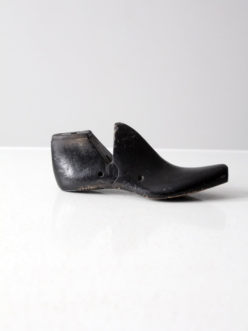 Early American Black Wood Cobbler Shoe Last Decorative Form: Early American Black Wood Cobbler Shoe Last Decorative Form This antique wooden cobbler's shoe last features a rich black finish and a sculptural, well-balanced profile. Its curved form and solid cons