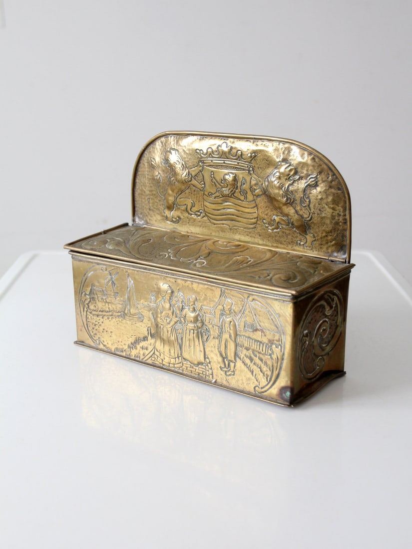 Antique Dutch Brass Candlebox with Village Scene Design: Antique Dutch Brass Candlebox with Village Scene Design Discover the charm of this vintage Dutch brass candle box, an exquisite piece of history. This antique box features a beautifully embossed desig