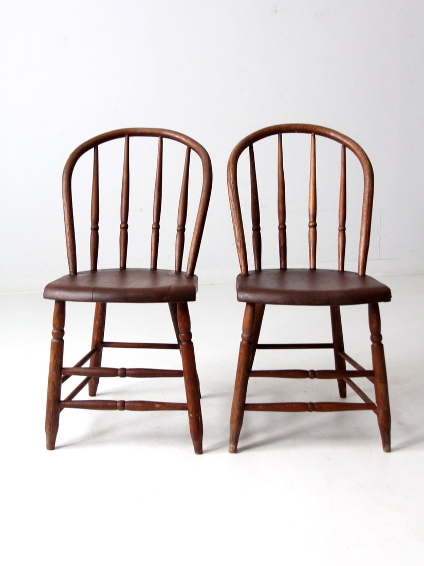 Classic Antique Windsor Bow Back Dining Chairs Pair: Classic Antique Windsor Bow Back Dining Chairs Pair This pair of classic antique wooden Windsor bow back dining chairs features elegant turned spindles, legs, and stretchers, making them a timeless ad