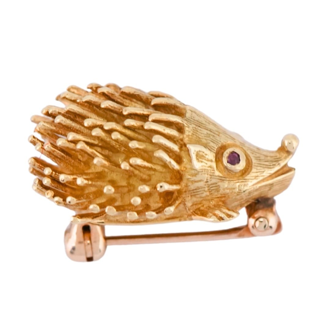 Vintage hedgehog brooch in 18K yellow gold with red eyes: Vintage hedgehog brooch in 18K yellow gold with red eyes Vintage hedgehog figural pin brooch crafted in stamped 18K yellow gold with finely detailed styling and two small round red stone eyes. The eye