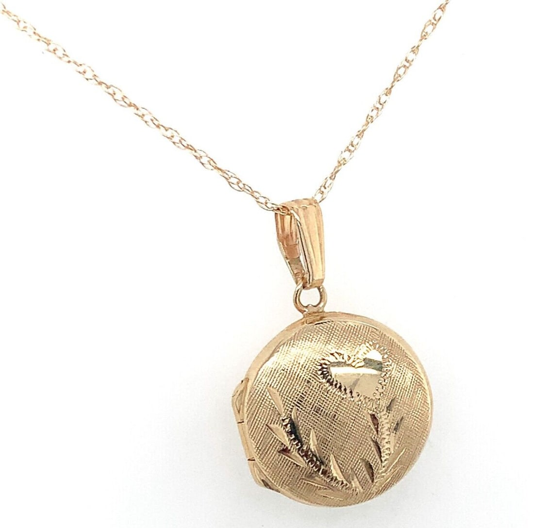 14k Yellow Gold Small Round Locket with Engraved Heart and Chain: 14k Yellow Gold Small Round Locket with Engraved Heart and Chain This exquisite 14k Yellow Gold locket features a very small round design adorned with a charming engraved heart. Crafted from quality y