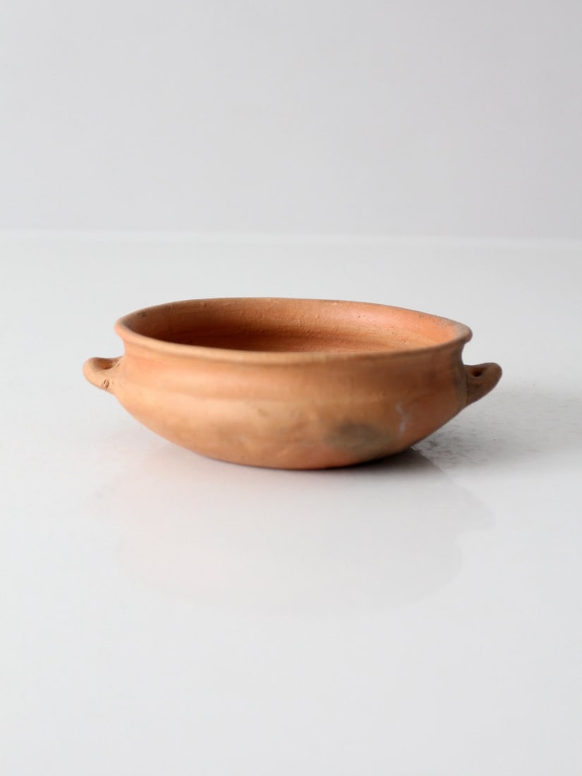 Antique Earthenware Bowl with Sculpted Loop Handles: Antique Earthenware Bowl with Sculpted Loop Handles Antique terra cotta bowl featuring a shallow rounded profile, rolled rim, and sculpted loop handles. The unglazed earthenware surface shows terracot