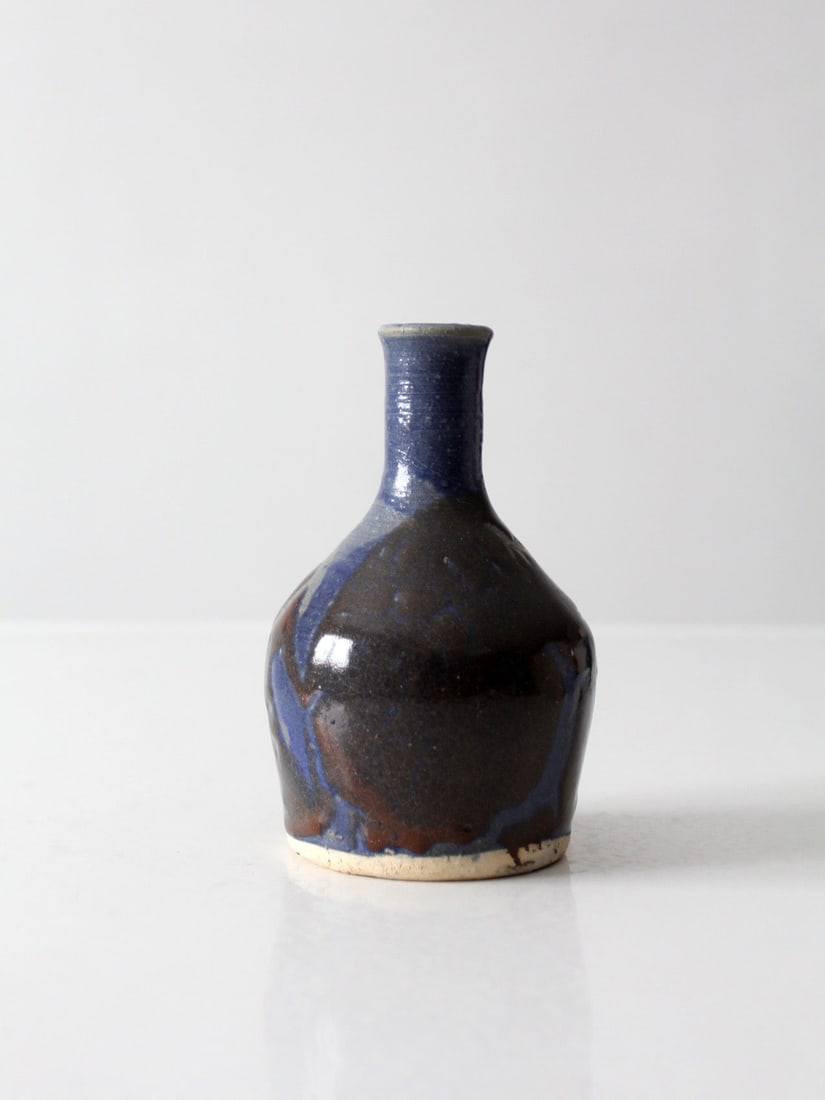 Handmade Studio Pottery Bud Vase Blue Brown Glaze 1970s: Handmade Studio Pottery Bud Vase Blue Brown Glaze 1970s Vintage handmade studio pottery bud vase from the 1970s featuring a rounded bottle form with flowing blue and earthy brown glazes. The layered g