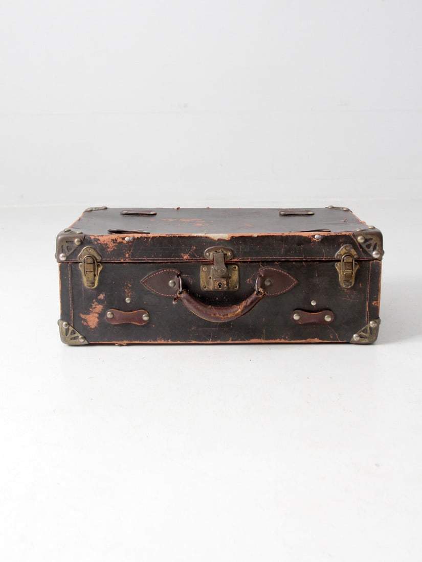 Circa 1930 Vintage Brown Cardboard Suitcase with Art Deco Design: Circa 1930 Vintage Brown Cardboard Suitcase with Art Deco Design This vintage suitcase, dating back to circa 1930, showcases a classic dark brown cardboard exterior complemented by metal art deco enfo