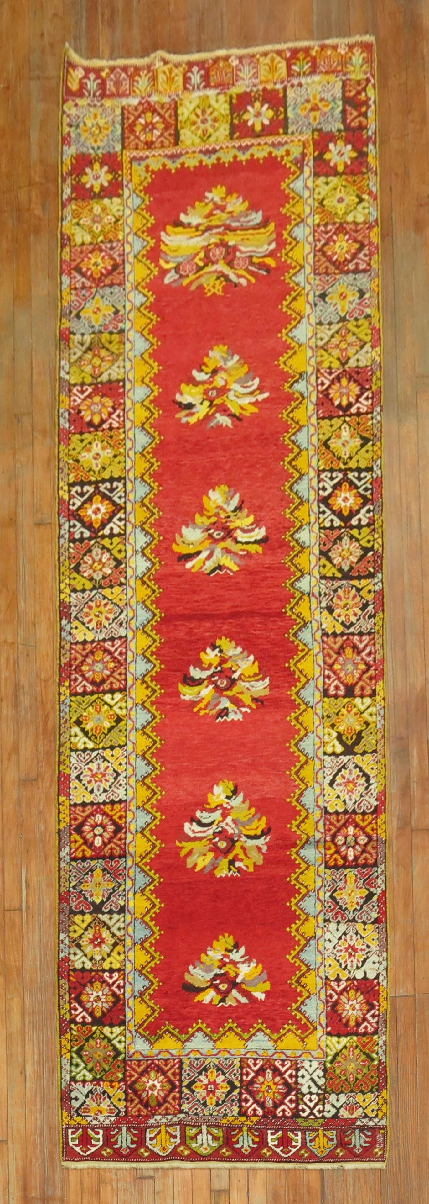Early 20th Century Mudjur Turkish Runner 3' 5" x 12': Early 20th Century Mudjur Turkish Runner 3' 5" x 12' An early 20th century Turkish runner featuring a wild, bright floral design. This pre-owned Mudjur runner offers a long, narrow format suited to ha