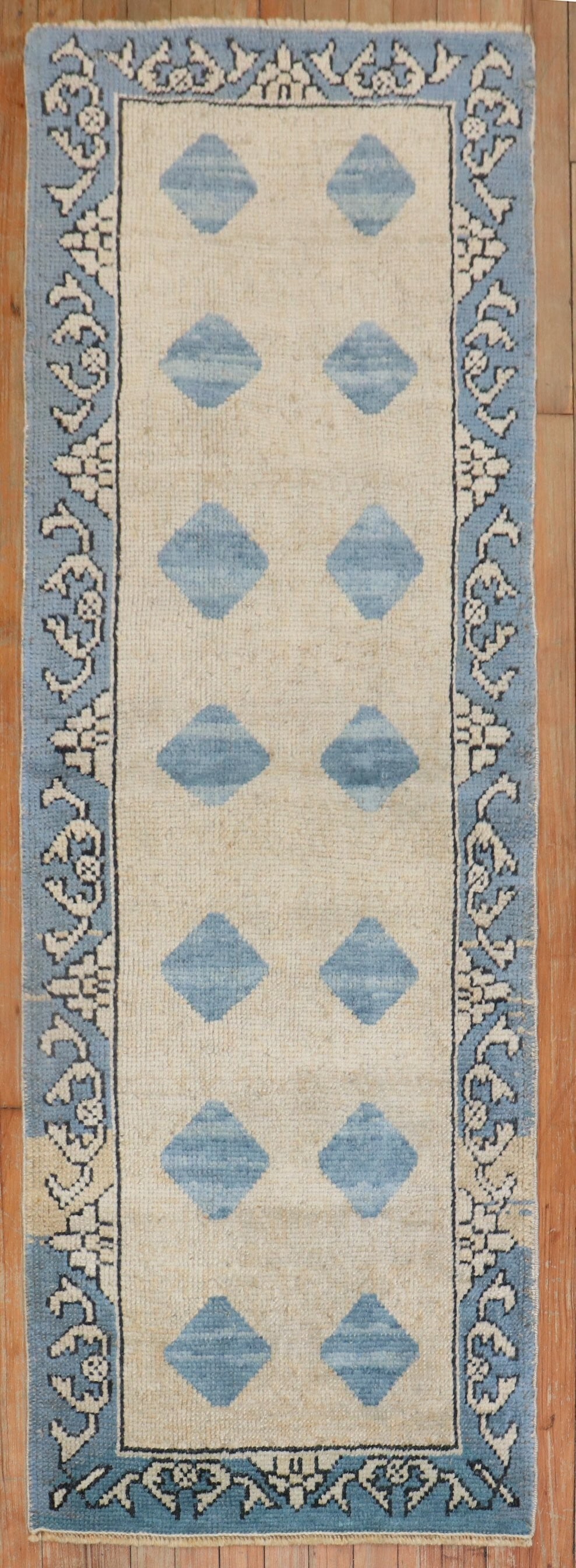 2' 2" x 6' Konya Turkish runner in beige and blue: 2' 2" x 6' Konya Turkish runner in beige and blue Mid 20th century Turkish runner in beige/tan and blue with a patterned design. Identified as a Konya type, this pre-owned runner offers a classic rect