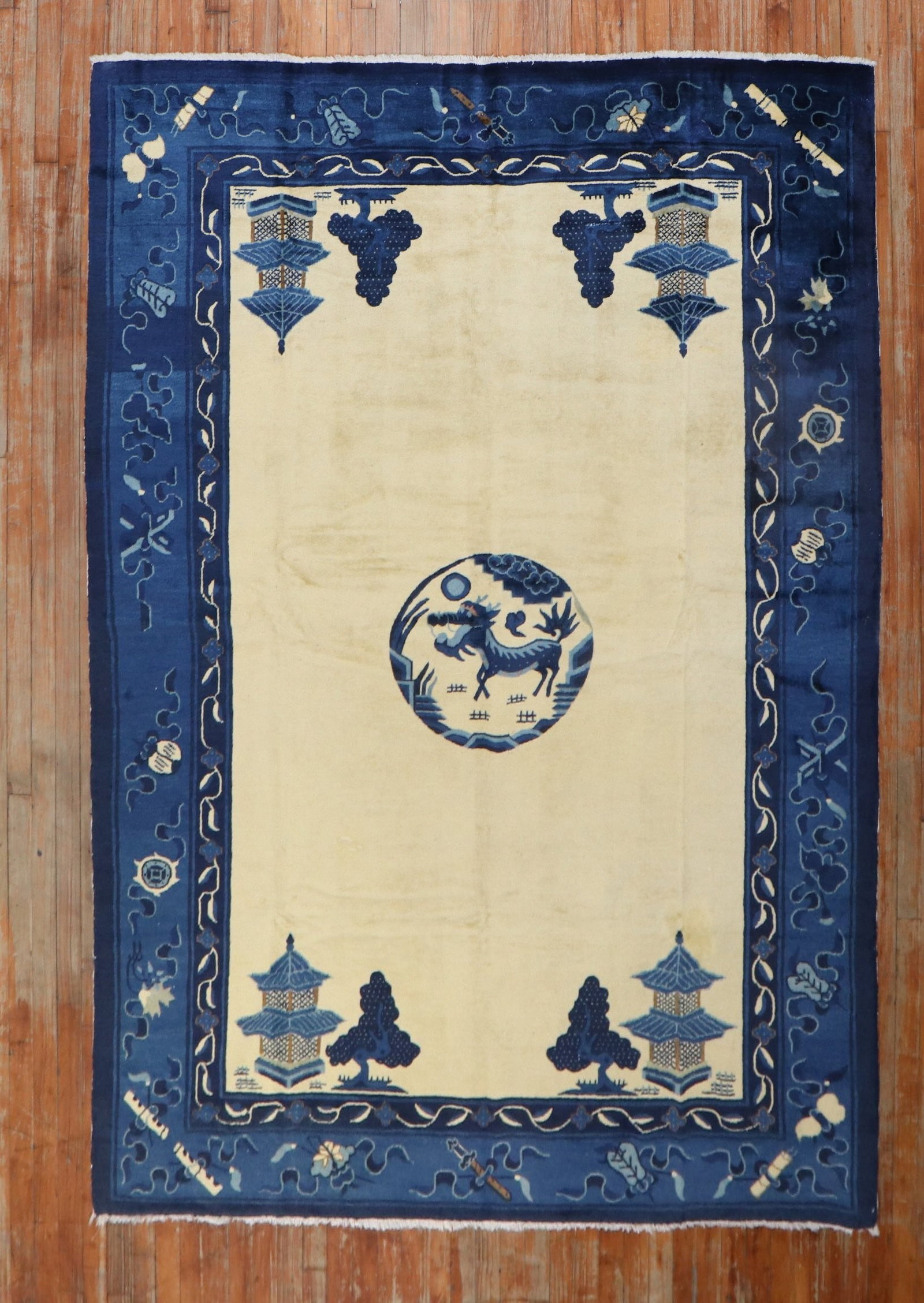 6' 2" x 8' 8" Peking rug with dragon medallion: 6' 2" x 8' 8" Peking rug with dragon medallion Early 20th century Chinese Peking rug featuring a spacious open field design on a creamy yellow ground with blue accents and a dragon inside a central me