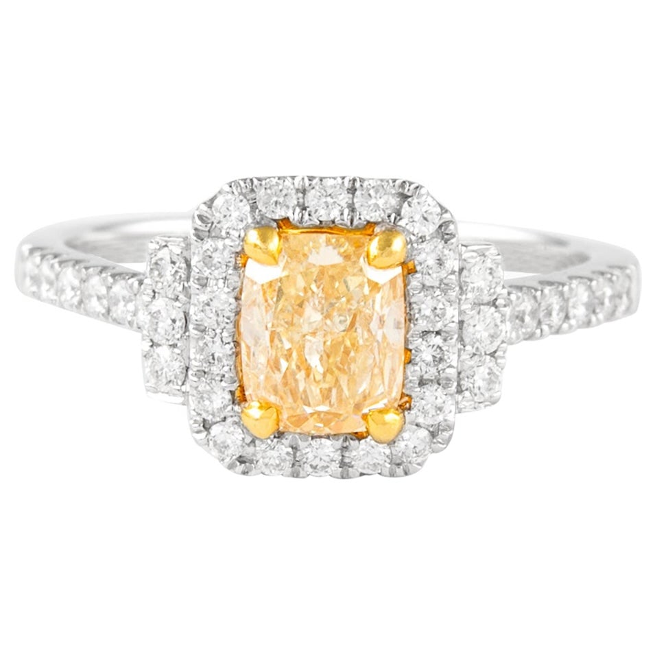 18k Two Tone Halo Ring 1.42ctt Fancy Yellow Diamond: 18k Two Tone Halo Ring 1.42ctt Fancy Yellow Diamond Contemporary halo ring set with a Fancy Yellow cushion-cut diamond and round brilliant accent diamonds. Crafted in two-tone 18k white and yellow gol