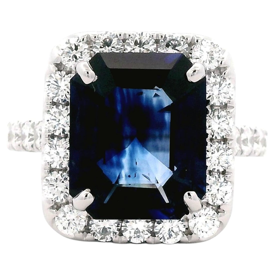 18k White Gold Ring GIA 5.45ct Ceylon Sapphire Diamonds: 18k White Gold Ring GIA 5.45ct Ceylon Sapphire Diamonds Contemporary ring featuring a natural blue emerald cut Ceylon sapphire surrounded by a diamond halo. The center stone is GIA certified, and the 