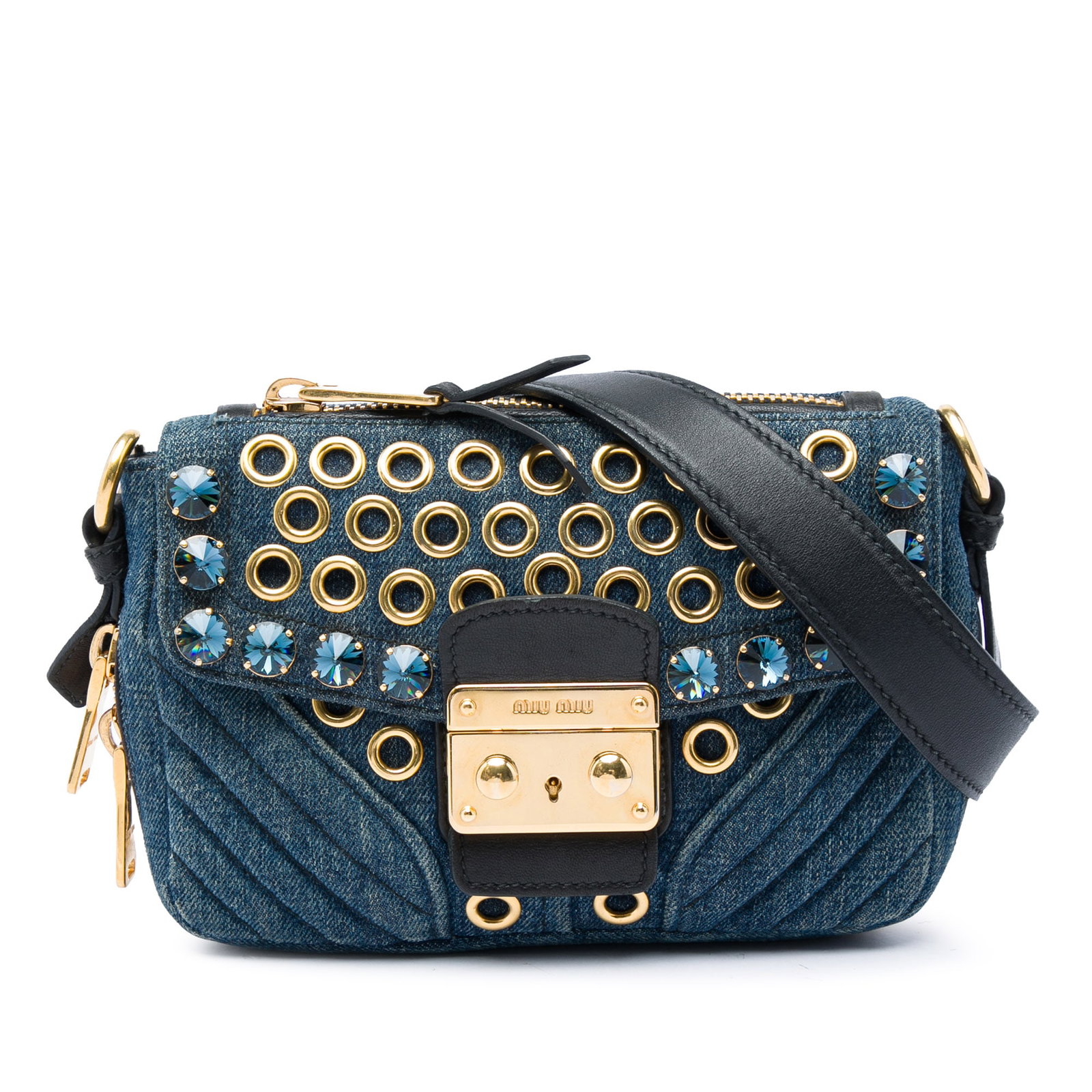 Miu Miu Biker Crossbody Bag in Blue Denim with Crystal Grommets: Miu Miu Biker Crossbody Bag in Blue Denim with Crystal Grommets A Miu Miu Biker crossbody bag in blue denim with grommet and crystal embellishments. It features an adjustable flat leather strap, a fro