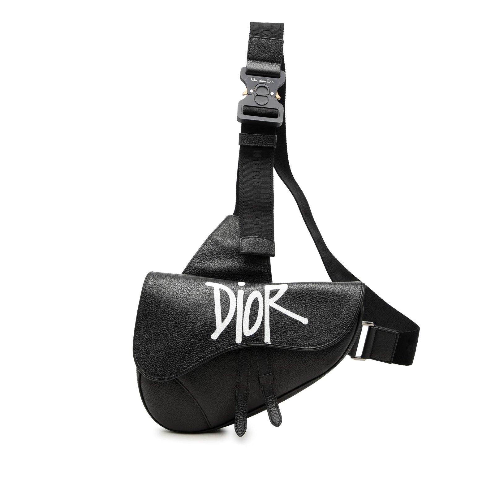 Dior Shawn Stussy Saddle Bag in Black Grained Calfskin: Dior Shawn Stussy Saddle Bag in Black Grained Calfskin Dior Shawn Stussy Grained Calfskin Saddle Bag in black leather with an adjustable flat shoulder strap, flap with magnetic snap closure, and top z
