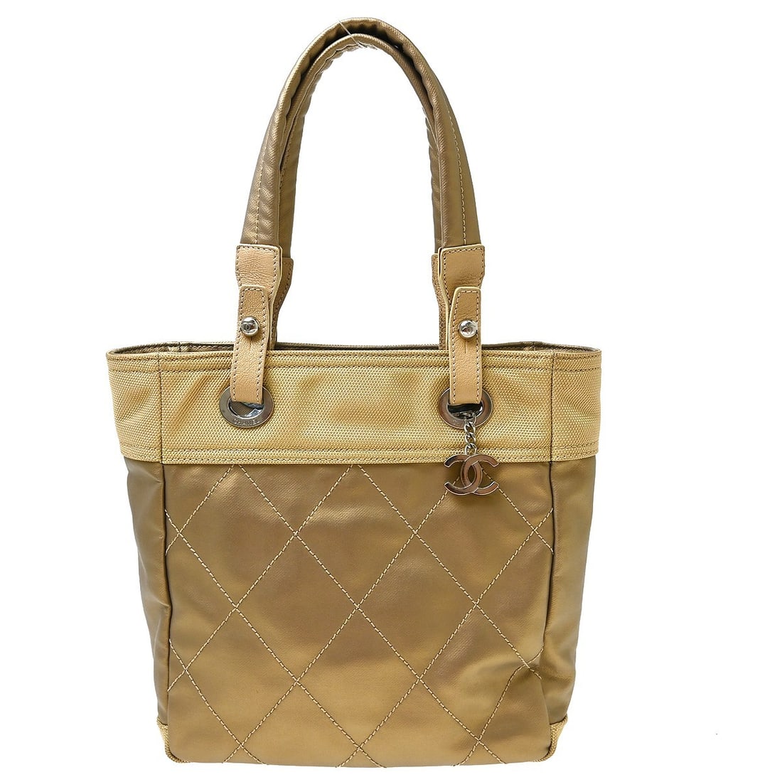 CHANEL Paris-Biarritz PM Tote Handbag in Gold Canvas: CHANEL Paris-Biarritz PM Tote Handbag in Gold Canvas Chanel Paris-Biarritz Tote PM handbag in gold canvas with double handles, zip closure, logo accents, and interior pockets. This medium tote is made