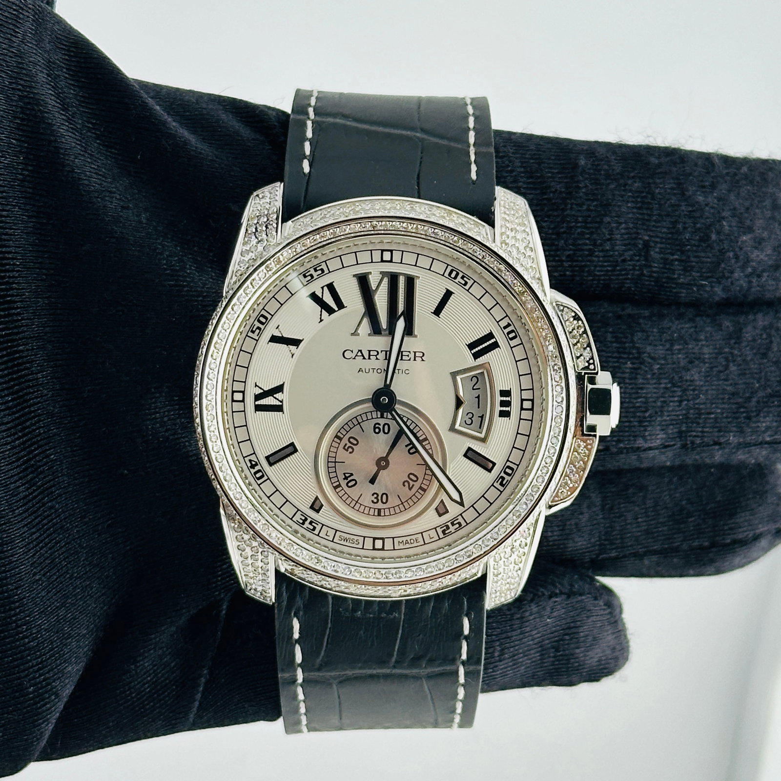 Cartier 3389 Calibre Iced Out Mens Watch Silver Dial aftermarket leather: Cartier 3389 Calibre Iced Out Mens Watch Silver Dial aftermarket leather This men's Cartier Calibre watch features a silver dial and a diamond bezel, paired with an aftermarket leather bracelet. The w