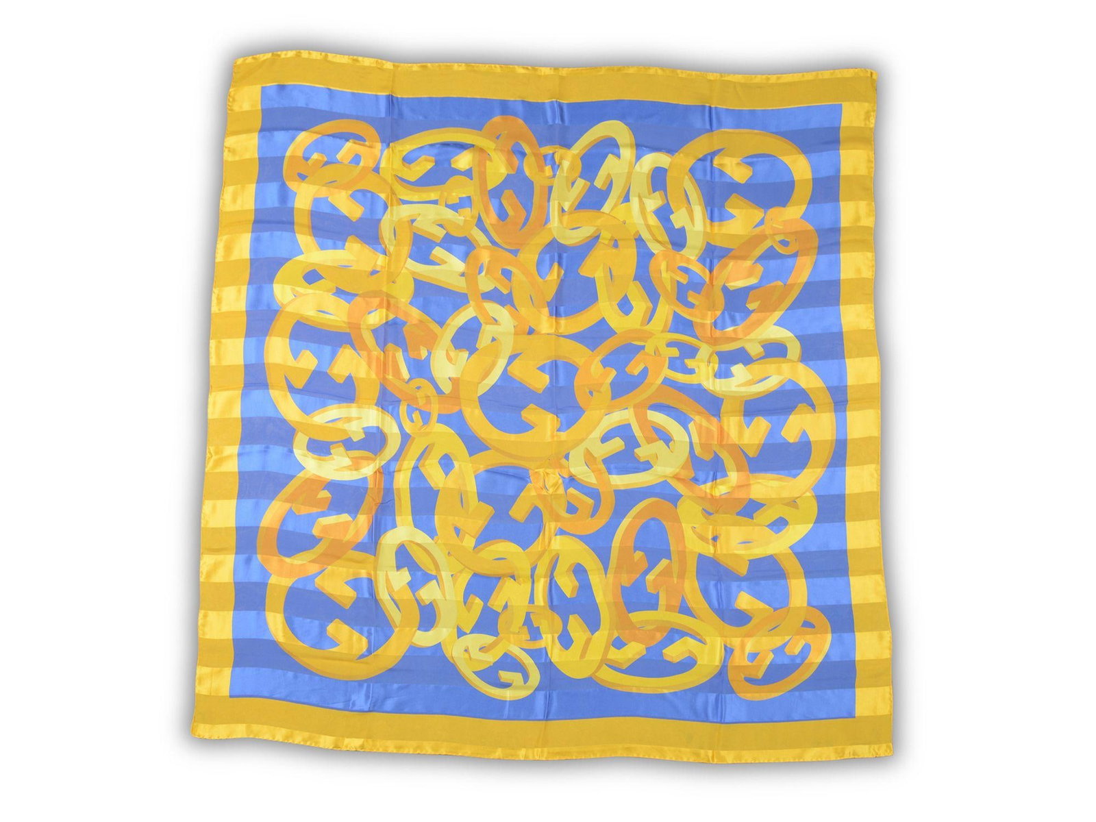 Gold and Blue Silk Chiffon Shawl with Gucci Logo Pattern 52 Inch: Gold and Blue Silk Chiffon Shawl with Gucci Logo Pattern 52 Inch Gucci oversize silk chiffon shawl in gold and blue, featuring a multi logo design. Made in Italy. This un-used accessory is crafted fro