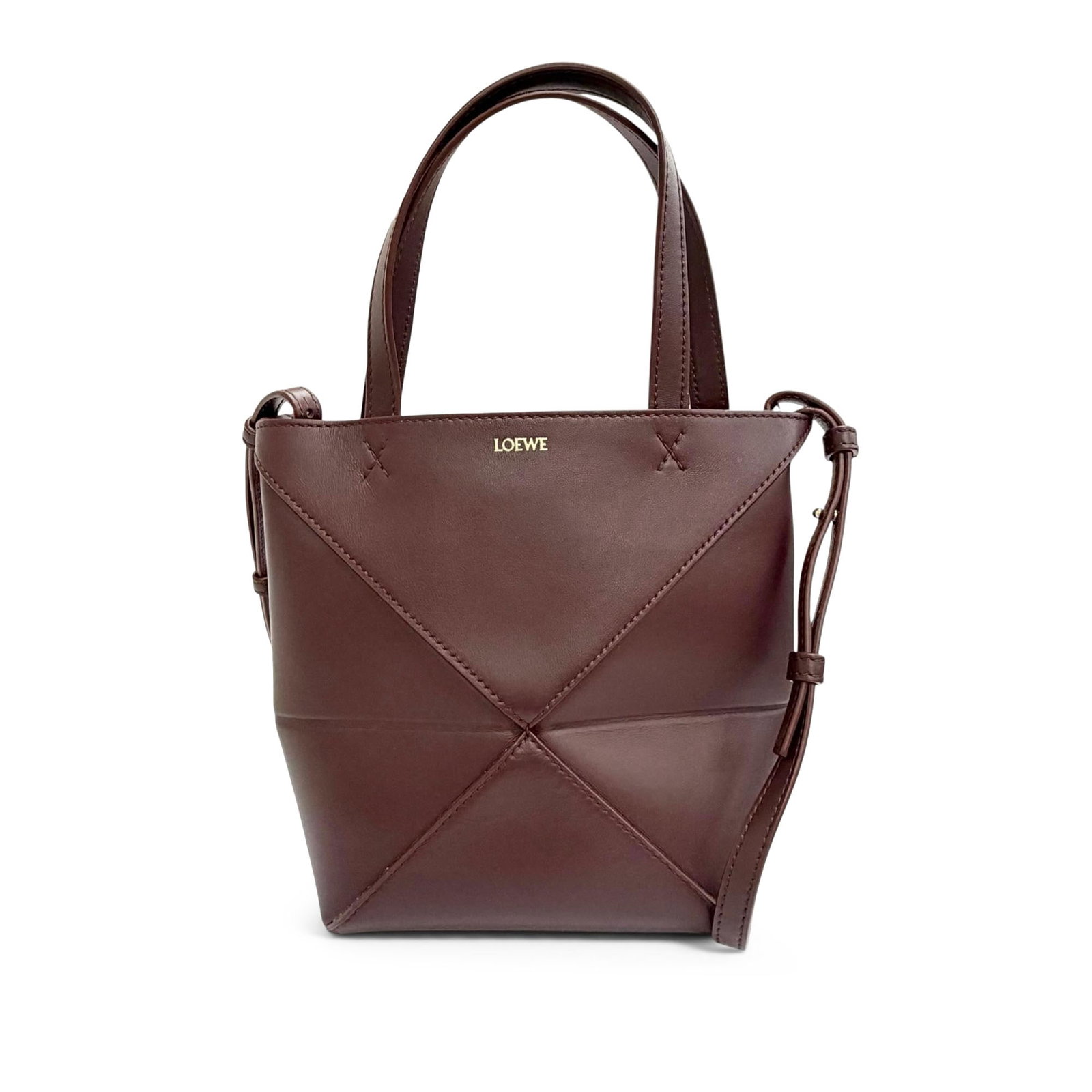 LOEWE Puzzle Fold Mini Tote in Shiny Calfskin Leather: LOEWE Puzzle Fold Mini Tote in Shiny Calfskin Leather The LOEWE Mini Shiny Calfskin Puzzle Fold Tote is a compact red leather satchel with flat leather handles, a detachable flat leather shoulder stra