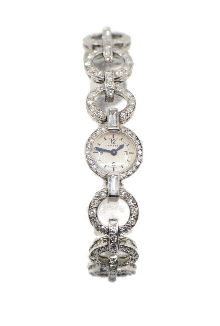 Cartier women's platinum wristwatch with diamond bezel manual movement: Cartier women's platinum wristwatch with diamond bezel manual movement Vintage Cartier wristwatch with a manual mechanical movement, analog display, and silver dial. This women's watch features a plat