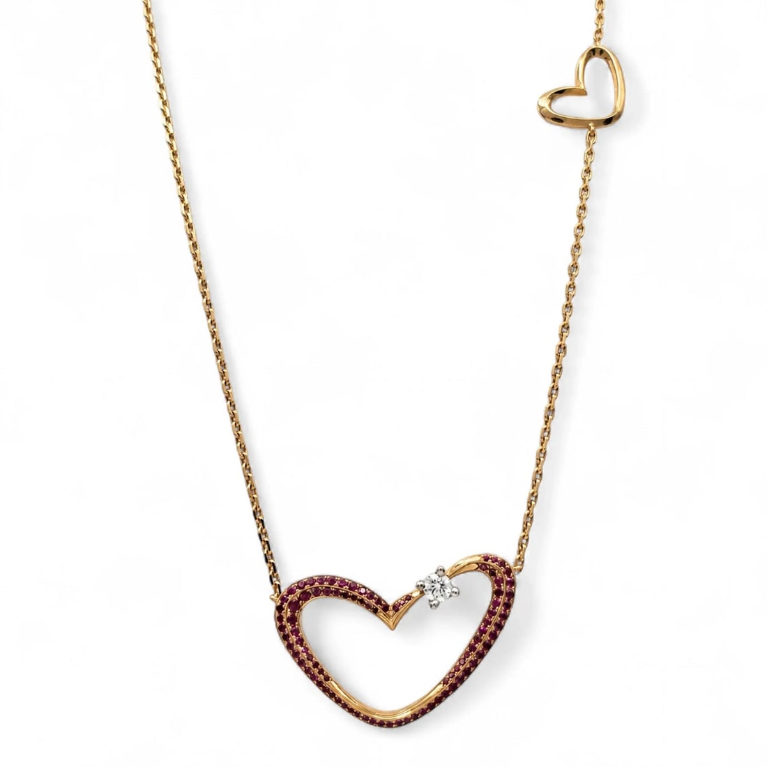 Gubelin 18K Rose Gold Heart Pendant Necklace with Ruby and Diamond: Gubelin 18K Rose Gold Heart Pendant Necklace with Ruby and Diamond Gubelin heart pendant chain necklace crafted in 18k rose gold with natural rubies and one round white diamond. The design features a 
