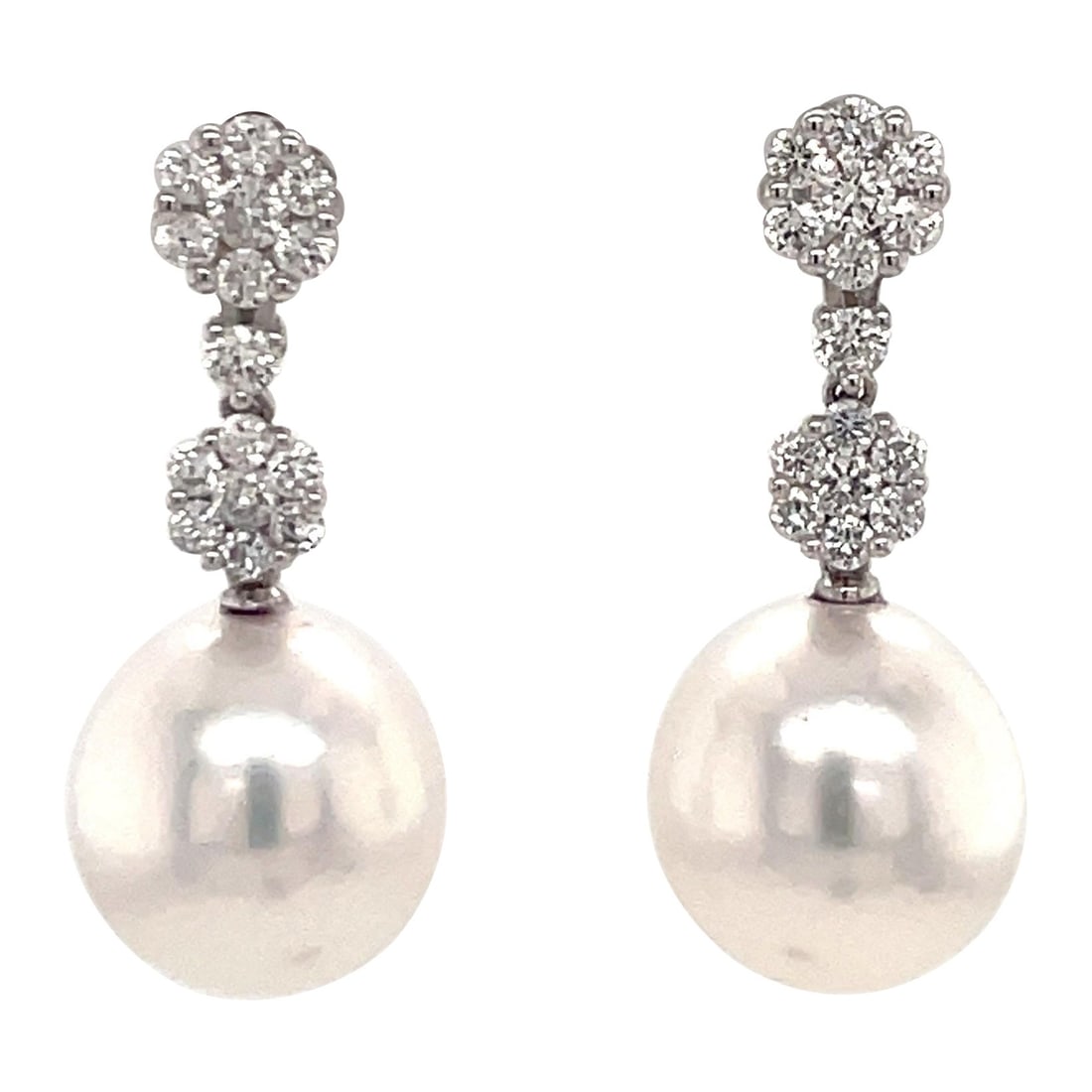 18K White Gold Drop Earrings with South Sea Pearls and 0.79 Carat Diamonds: 18K White Gold Drop Earrings with South Sea Pearls and 0.79 Carat Diamonds Contemporary drop earrings crafted in 18K white gold, featuring two South Sea pearls and round-cut diamond clusters. The desi