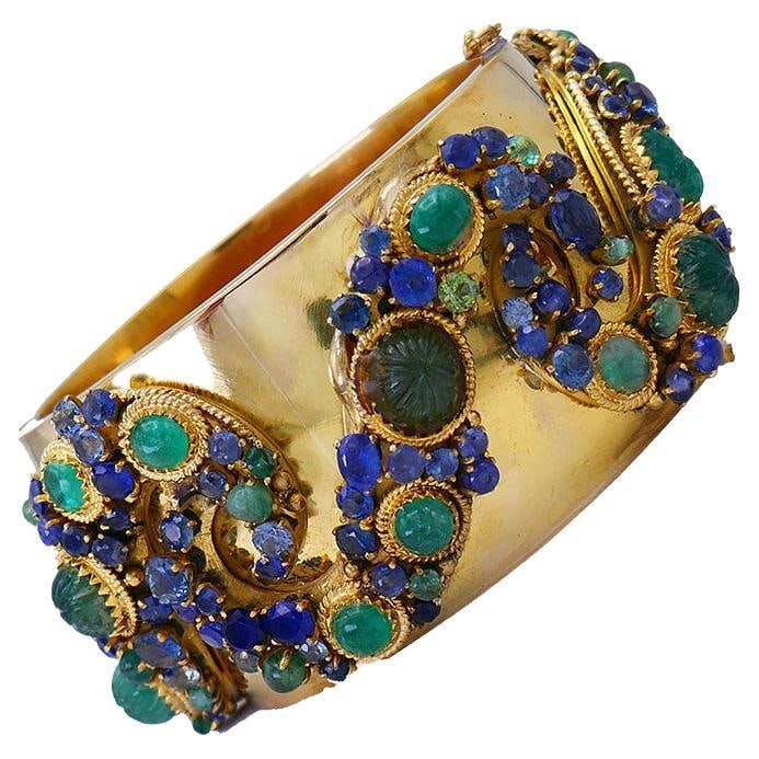 14k Yellow Gold Bangle Bracelet with Emerald and Sapphire: 14k Yellow Gold Bangle Bracelet with Emerald and Sapphire Chic vintage bangle bracelet made of 14 karat yellow gold with cabochon, beaded, and faceted emeralds and sapphires. It is a colorful, wearabl