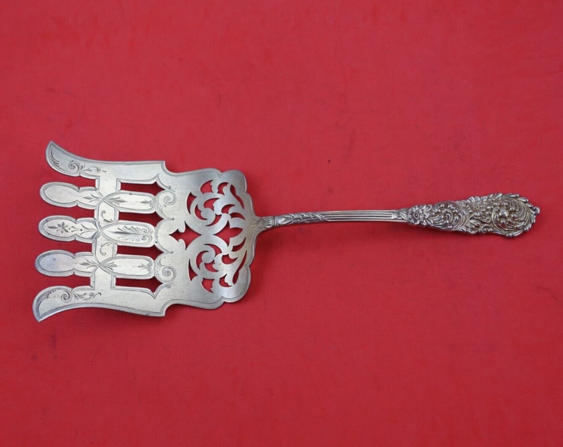 Reed and Barton Trajan Sterling Silver Fancy Pierced Asparagus Fork 9 5/8": Reed and Barton Trajan Sterling Silver Fancy Pierced Asparagus Fork 9 5/8" Discover the elegance of the Trajan Sterling Silver Asparagus Fork by Reed & Barton. This exquisite serving fork, measuring 9
