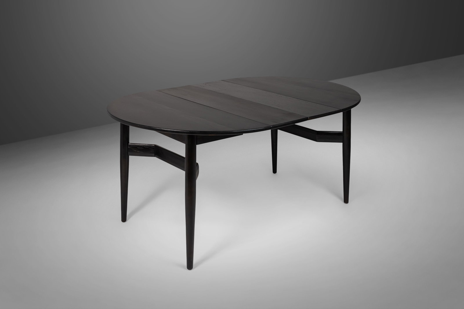 Mid Century Modern Ebonized Walnut Extension Dining Table with Architectural Legs: Mid Century Modern Ebonized Walnut Extension Dining Table with Architectural Legs This stunning Mid Century Modern dining table features an ebonized finish in a silky jet-black stain, combining functi
