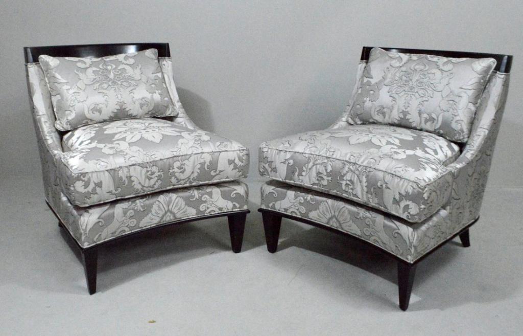 Pair of Ambella Klismos Wingback Chairs: Each with a shaped crest rail over a fully upholstered back, seat and cushion, the whole raised two tapering rectangular legs on the front and two splay legs on the rear. Upholstered in silver Damask