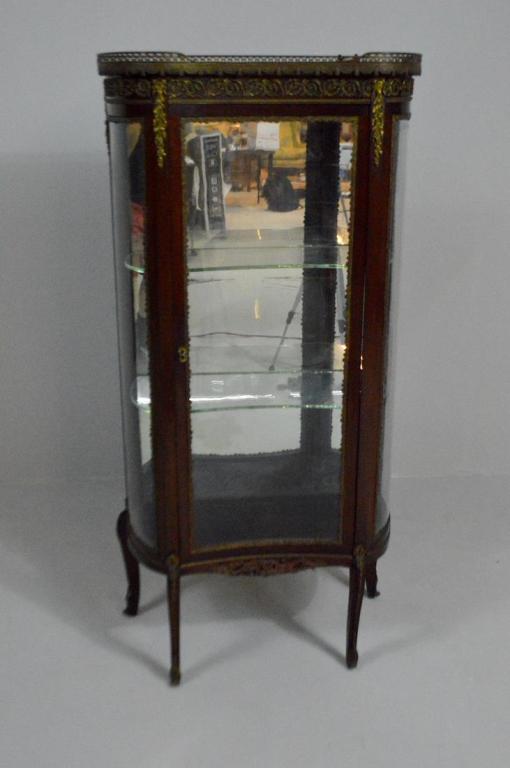 Louis XV Style Curio Cabinet: With a galleried, mottled brown kidney-form marble top over an apron mounted with garland and scrolling acanthus ormolu, over a large central glazed door opening to reveal two glass shelves and a mirr