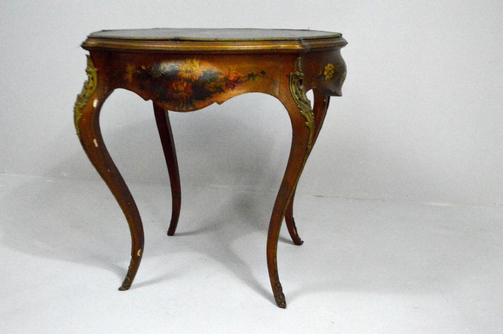 Louis XV Style Polychrome Center Table: With a shaped and moulded leather top painted with a courtship scene, and surrounded by ormolu mounts, the moulded apron decorated with painted bouquets, the whole raised on four ormolu-mounted cabrio