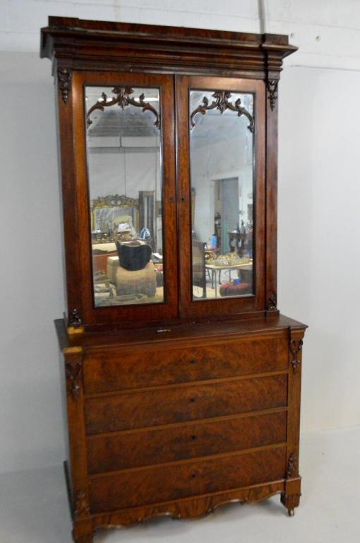 Revival Mahogany Secretary Bookcase: In two parts, the upper part with a shaped cornice over two mirrored doors opening to reveal three shelves and three drawers, the lower part with four drawers, the top drawer opening to reveal a felt 