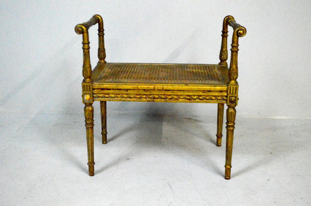 Louis XVI Style Caned Bench: With turned and carved rails over carved stumps flanking a caned seat over a carved apron, the whole raised on four turned, carved and fluted tapering round legs.