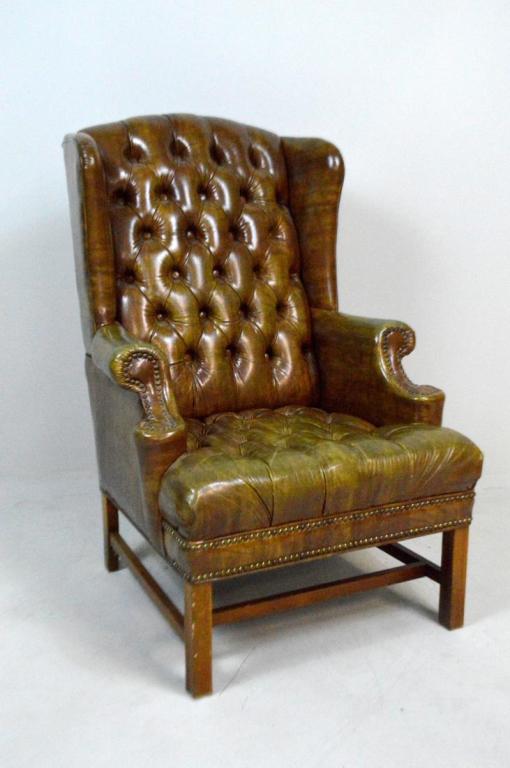 George III Faux Leather and Mahogany Armchair: With attenuated wings and scrolling arms flanking a tufted back and seat, the whole raised on four rectangular legs supported by an H-stretcher.
