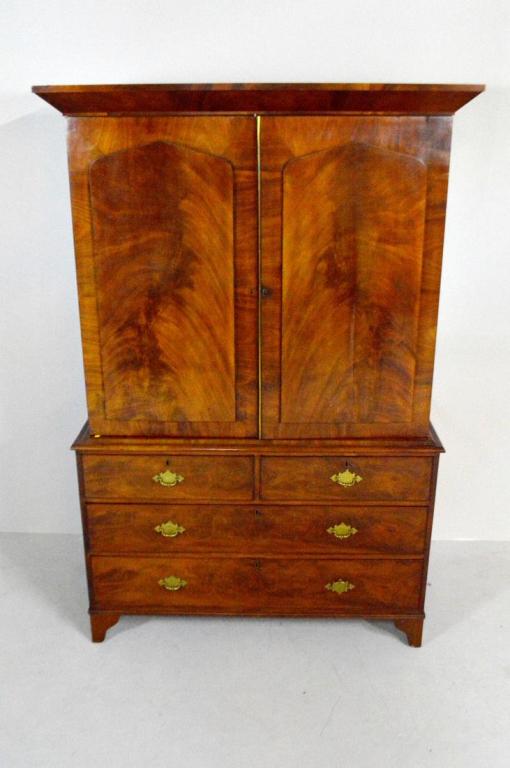 George III Style Mahogany Linen Press: In two parts, the top with a mounted pediment over two doors opening to reveal a single hanger rod, the bottom with a moulded edge over two half and two full drawers, the whole raised on bracket feet.