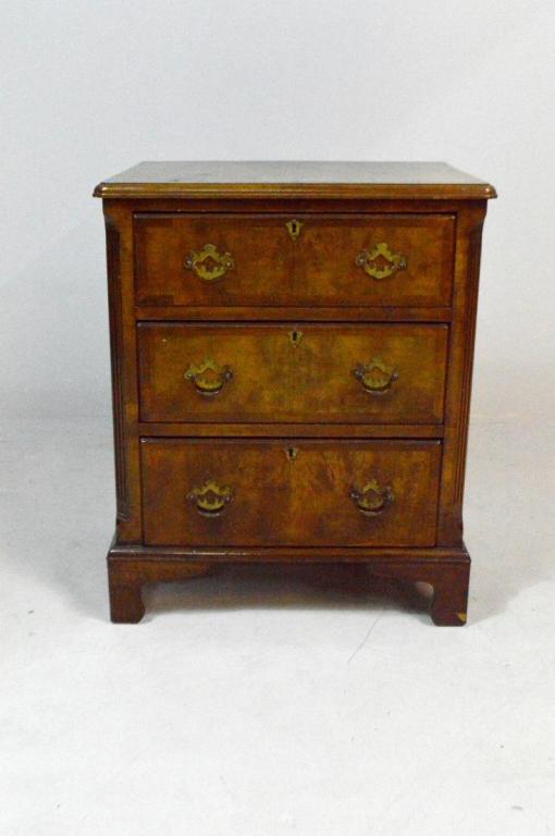 George III Style Mahogany Bachelor's Chest: With a moulded and shaped rectangular top over three drawers flanked by fluted and chamfered sides, the whole raised on four ogee bracket feet.