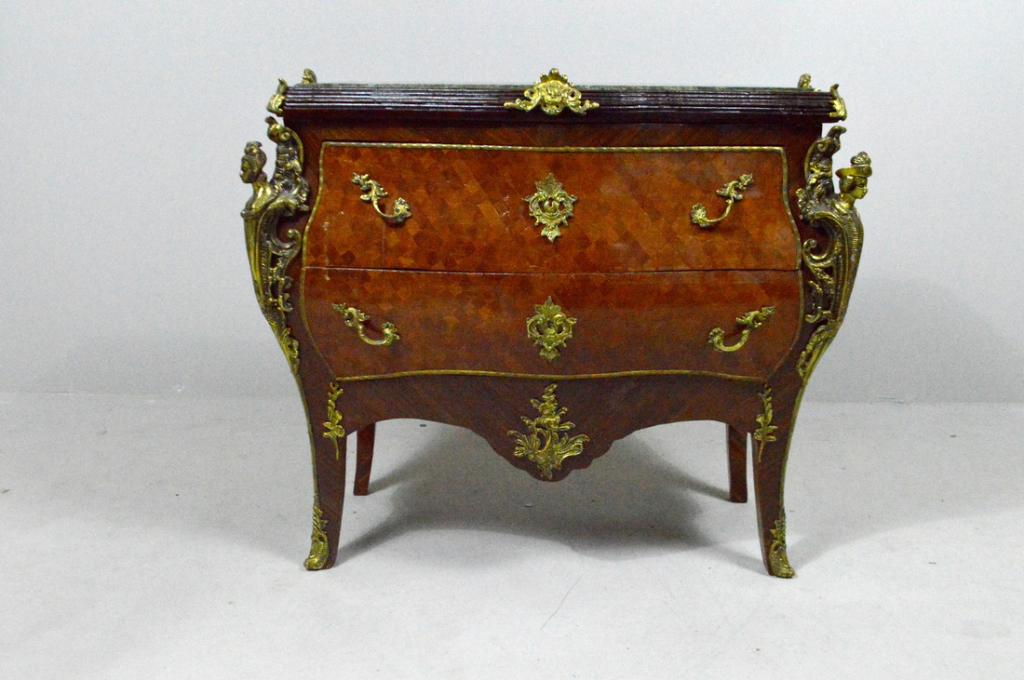 Louis XV Style Mahogany Bombe Commode: With an inset shaped green marble top over two shaped drawers flanking brass mounts of maidens, the whole raised on two brass mounted cabriole legs to the front and two rectangular legs to the rear.