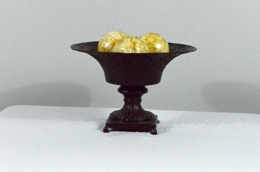 Patinated Metal Urn and Bone Spheres: With a wide chased lip, raised on a square base with four ball feet. Includes three wood balls.