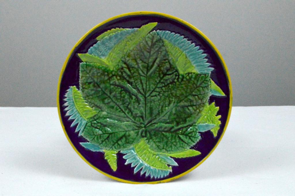 George Jones Fern and Leaf Plate: With a central green maple leaf over fern fronds, on a cobalt ground with yellow edge rim, marked on base.