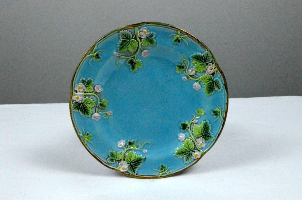 George Jones Majolica Strawberry Plate: With a light blue ground with five ivy sprigs with blooms, marked on base.