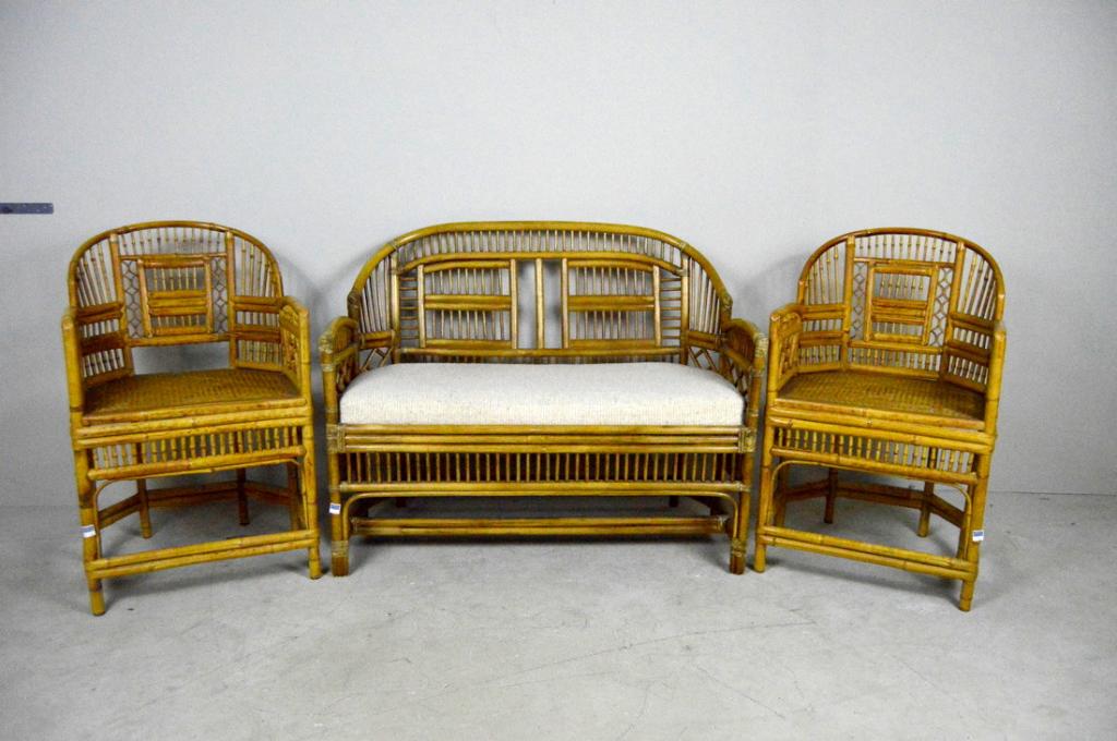 Brighton Pavilion Style Bamboo Parlor Suite: A Brighton Pavilion style settee and pair of chairs each with backs and arms of bamboo over cane woven seat. The settee with a white cushion, the chairs raised on six bamboo legs supported by stretche