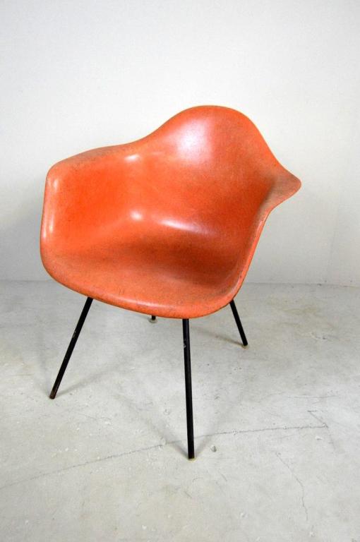 1957 Charles and Ray Eames Herman Miller Shell Chair: Orange fiberglass shell chair, with original paper label, Stamped November 20, 1957. 31.25 x 24.75 x 23 in. NOTE: one anchor screw missing