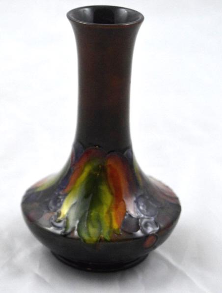 Moorcroft Stem Vase: Auburn ground with grapes and orange, green and yellow leaves. Signed and marked on base. 6 x 4 in.