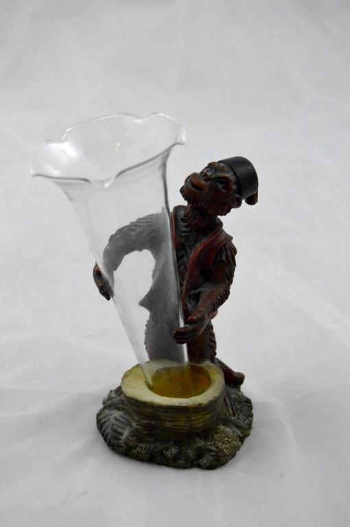 Monkey Form Bud Vase: Of a monkey wearing a vest and fez holding a glass trumpet vase. 6 x 3 x 3 in.