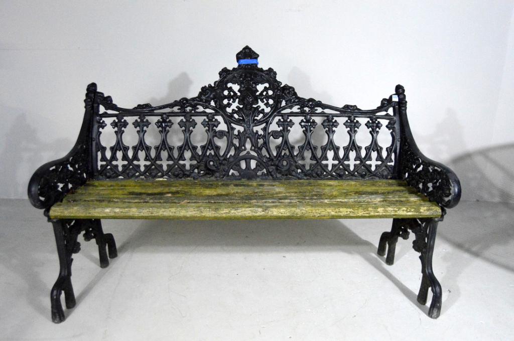 Cast Iron Garden Bench: The back with crest in an oval escutcheon with well-weathered seat raised on stem-form legs 37 x 56.5 x 24 in.