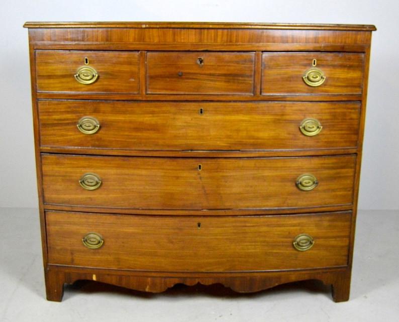George III Mahogany Bowfront Chest of Drawers: Circa 1840, with a shaped and moulded rectangular top, with veneer apron, over three drawers over three full sized drawers, over a shaped apron, the whole raised on four bracket feet. 40 x 46 x 22 in.
