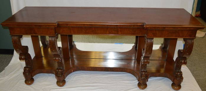 Regency Style Mahogany Pier Table: With a shaped rectangular top with moulded edges over four ogee form carved legs, the shaped base over a mirrored back, the whole raised on eight bun feet. 36 x 79 x 21 in. Property of the