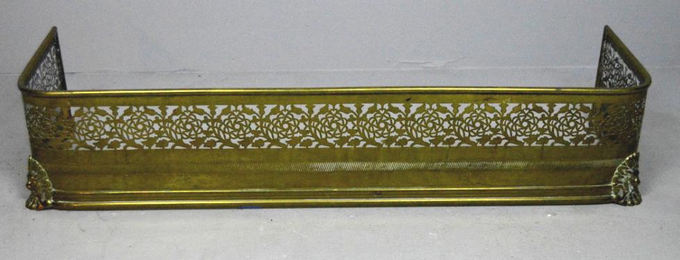 Brass Fireplace Fender: With pierced and etched body with lion's faces at the corners 9 x 42 x 12 in.