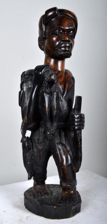 20th Century African Hunter Statue: Africa, ironwood. A hunter is carrying fish on his shoulder with detailed carving throughout. 20 x 5 in Condition: Wear consistent with age and use Property of Anthony French. Sr.