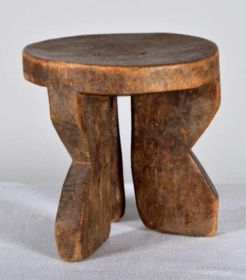 African Tripod Stool: African, wood, 20th Century; of usual form, with round surface and three shaped legs. 9 x 8 x 8 in. Condition: Wear consistent with age and use Property of Anthony French. Sr.