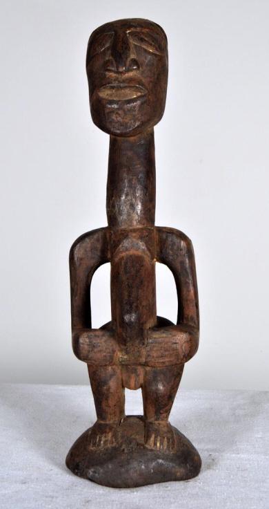 Bambara Wood Statue: West African, 20th Century, wood; The carved statue of a man with elongated neck and the stomach protruding the legs are resting on the base that is carved in the piece. 17.5 x 4.5 in. Condition: Wear