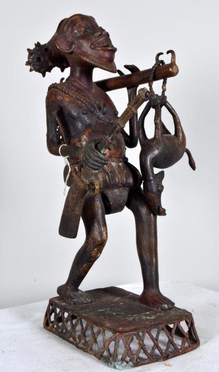 Benin Bronze of a Hunter: Benin ,Bronze , West African ; The hunter has a rifle, deer, and a fishing net on bronze stand 19 x 5.5 x 12 in. Condition: Wear consistent with age and use Property of Anthony French. Sr.